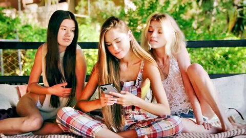 Evelin Elle, Sonya Blaze, Molly DeVon in revealing outfits checking phone outdoors