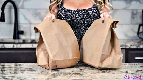 Gigi Dior blonde MILF in low-cut black floral dress holding bags