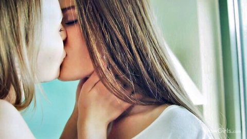 Two young blonde lesbians passionately kissing closeup with hands on neck