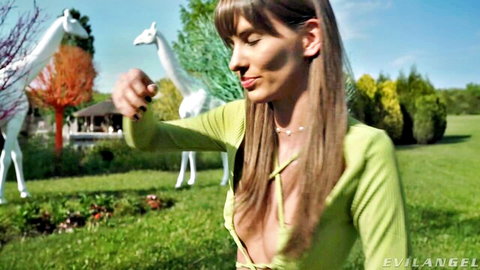 Brunette in low-cut green top gesturing outdoors with giraffes - Rocco Siffredi scene