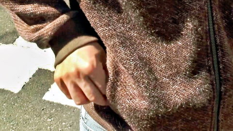 Teasing woman in brown tweed jacket, hand in pocket, outdoor vibe