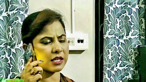 Seductive Indian Bhabhi in orange top on intense phone call, teasing vibe