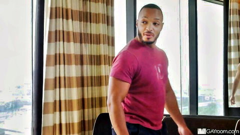 Muscular black man in red shirt posing confidently post-baseball game