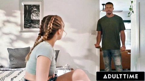 Skinny blonde with braids in tight crop top and shorts sits on bed teasing man in doorway