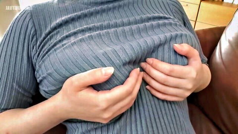 Asian woman in tight gray sweater squeezing her large breasts, teasing masochistic nipples