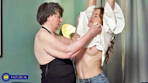 Sharon Amore lifts Nicole Murkovski's shirt, exposing her bare breasts in mature lesbian tease