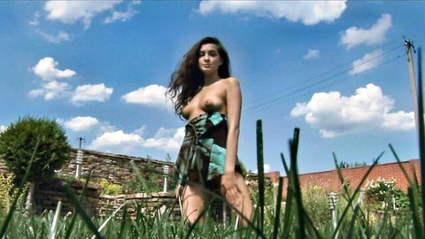 Topless brunette beauty in green skirt posing in sunny garden