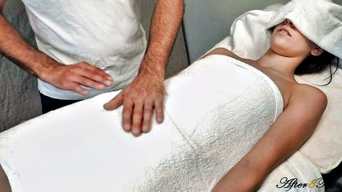 After8Teen blindfolded on massage table, man's hands on her towel-covered body