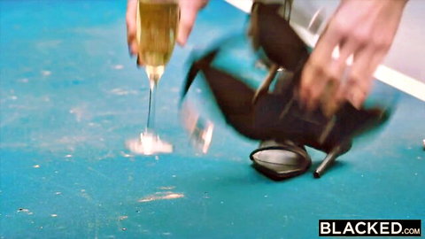 Fair hands spilling champagne next to black high heels on pool table in Blacked scene