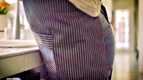 Charlie Forde in teasing apron pose, curvy blonde MILF