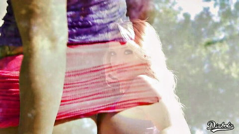 Blonde vixen peeking through hiked-up colorful skirt outdoors
