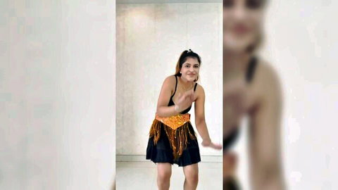 Sexy Indian babe teasing in tight black top and fringed mini skirt showing cleavage and thighs