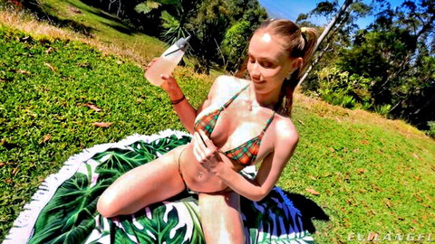Blonde beauty in skimpy bikini lounging on grass, POV tease outdoors