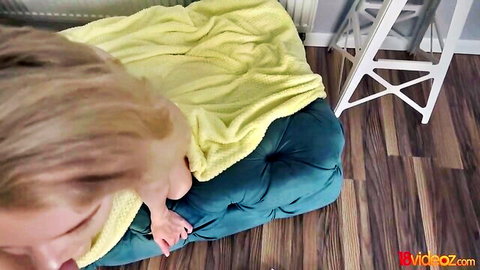 Blonde skinny teen lying on turquoise ottoman under yellow blanket in POV with open mouth