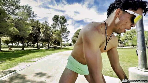 Muscular shirtless hunk in tight lime green briefs teases big bulge on park pole outdoors