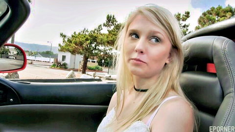 Petite blonde babe with small tits pouts naughtily in tight white top in red sports car