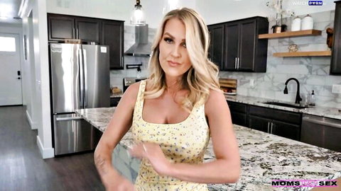 Blonde MILF Andi Avalon in floral yellow dress teases with cleavage