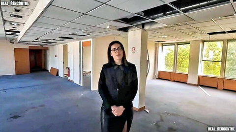 Sexy MILF realtor in tight black dress and glasses in empty office