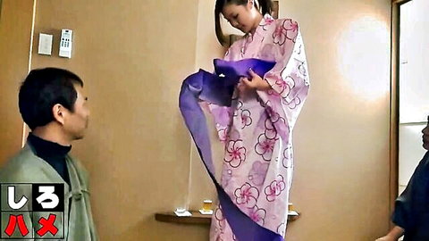Japanese woman in pink floral kimono lifts purple sash teasing two watching men