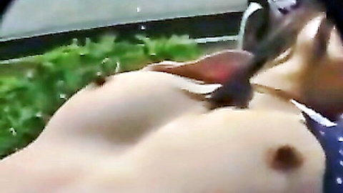 Topless Japanese woman with large breasts lounging outdoors near water