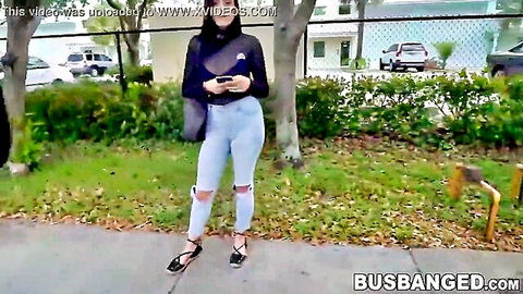 Selene Sinclair in ripped jeans and strappy heels outdoors on the road