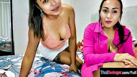 Two busty Thai babes teasing with deep cleavage in sexy tops on bed