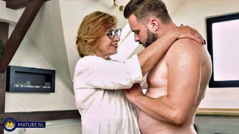 Mature redhead Petra in robe embraces naked muscular man