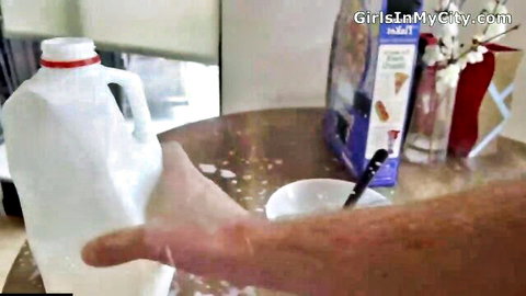 Hand pouring milk from jug into cereal bowl, accidental slip tease