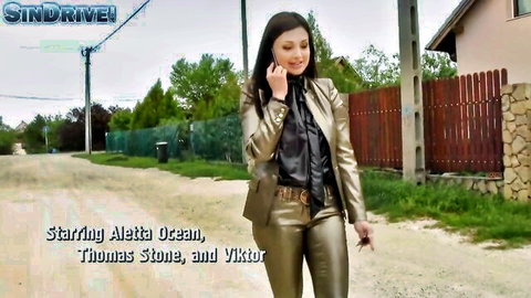 Aletta Ocean in sexy gold leather suit, talking on phone outdoors