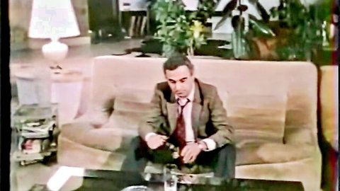 Suited single man lounging in 1984 French adult scene with Cathy Stewart