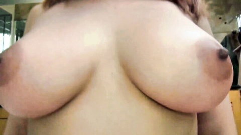 Busty Asian woman topless, close-up of large bare breasts and pink nipples