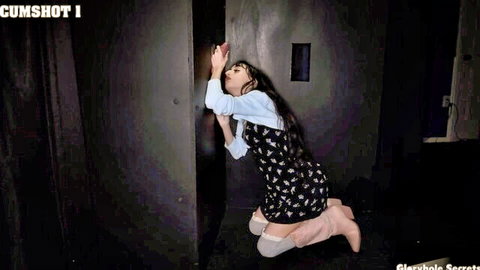 Ronnie Violet kneeling at glory hole in polka-dot dress, cumshot tease