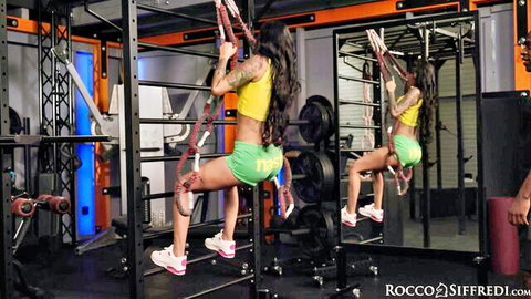 Tattooed brunette babe in tight gym shorts during workout