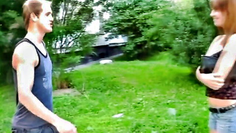 Redhead in short shorts chats with muscular guy outdoors, teasing vibe