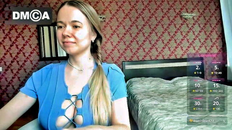 Blonde cam girl Roxxana in revealing blue lace top, smiling seductively