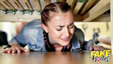 Buxom blonde with braids entangled under mattress in denim jacket