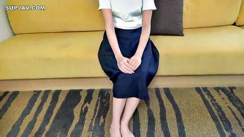Asian female medical student in white blouse and dark skirt sitting demurely