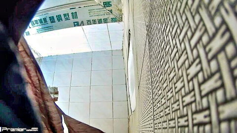 Voyeur cam captures empty Chinese bathroom stall with white tiled floor and bamboo wall