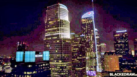 Stunning Los Angeles downtown skyline at night lit in vibrant blues and purples with BlackedRaw watermark