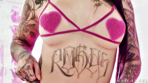 Tattooed woman in sheer pink bra revealing roses belly tattoo