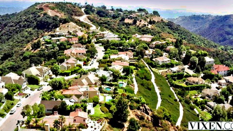Aerial view of luxurious hilltop neighborhood in Vixen video with fit blonde oral scene