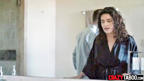Curly-haired wife in black robe with husband in steamy bathroom scene