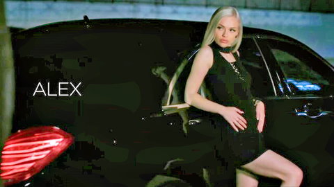 Alex Grey posing seductively in black dress by luxury car