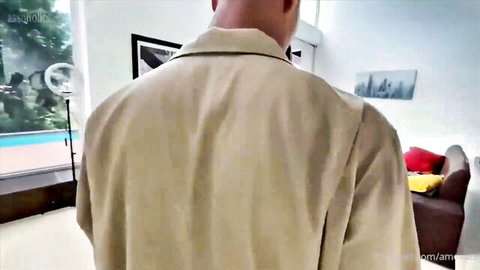 Man in beige shirt from behind in room with pool view