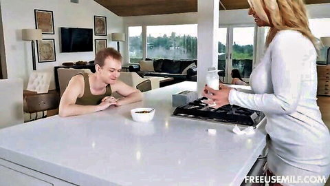 Blonde in tight white dress serves milk to man at breakfast in family freeuse