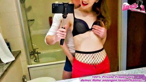 Brunette in fishnet bra squeezes her exposed tits for boyfriend's bathroom mirror selfie