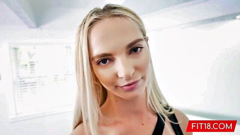 Sexy long-haired blonde teen smiling seductively in tight black top