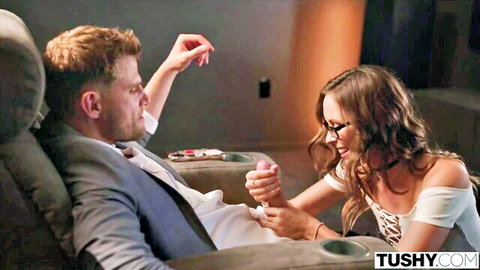 Brunette with glasses strokes suited guy's hard cock in intense handjob on recliner