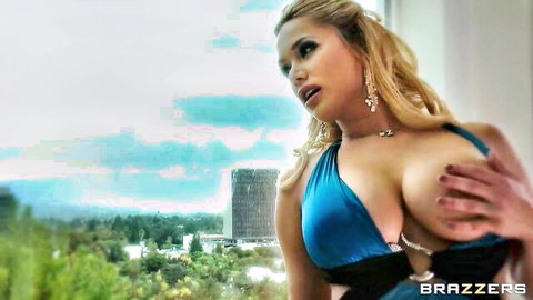 Shyla Stylez in revealing blue dress, teasing cleavage on balcony