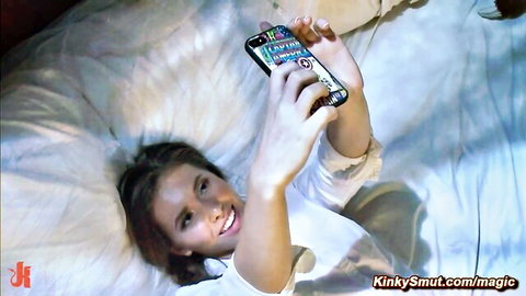 Cute smiling babe taking selfie on bed in white top teasing naughtily